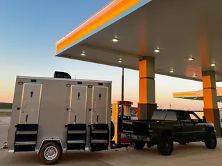 A restroom trailer hitched to a pickup truck