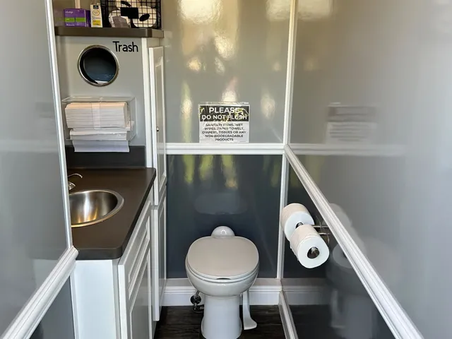Inside one of our restroom trailers, with a sink, a toilet and supplies