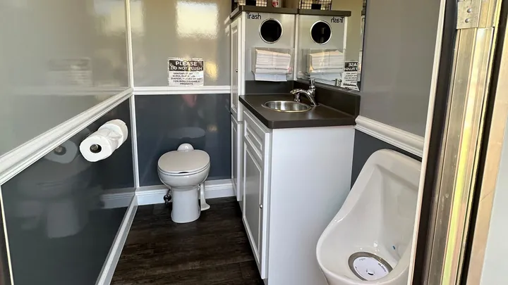 Inside the 3-Stall Restroom Trailer, with a sink, a toilet and a urinal